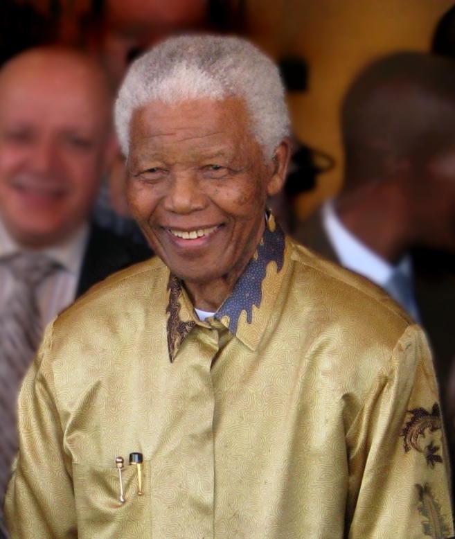 An elderly Nelson Mandela wearing a gold Madiba shirt.