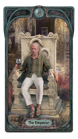 The Emperor sits on a cared stone throne amidst ruins, contemplating the glass of wine he holds. His clothing is contemporary casual and a carved snake on teh back of his throne can be seen rising just above the position of his head.