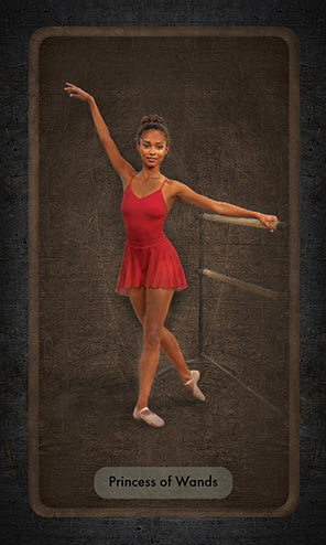 The Princess of wands is a young Black ballet dancer practicing at the barre. She wears a red leotard and chiffon skirt. She looks at the viewer with cheerful confidence. She poses with her right arm raised gracefully above her head, while the other hand holds the barre. Her right foot is extended gracefully behind her.